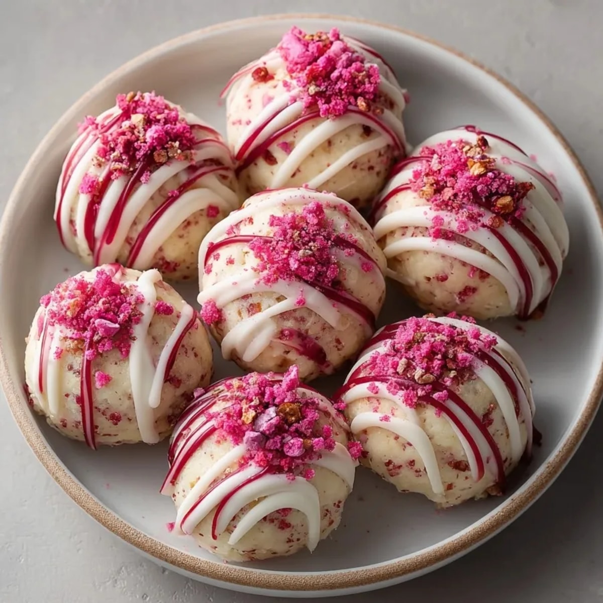 Close-up of Strawberry Shortcake Energy Bites glowing with creamy texture, freeze-dried strawberries, and sweet chocolate topping.