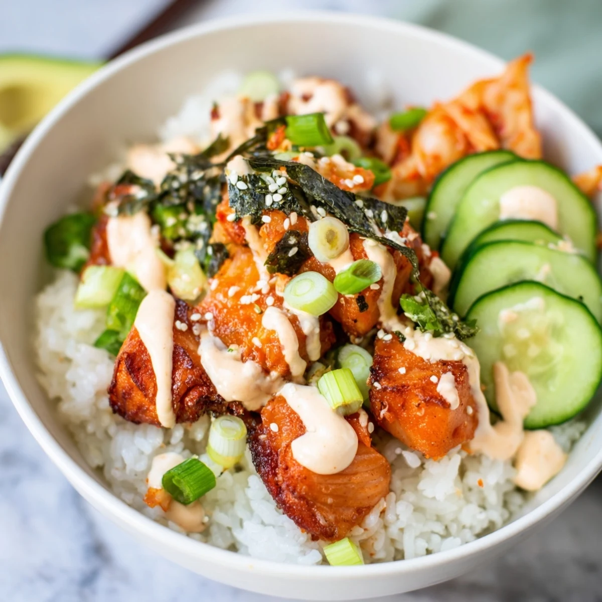 Deliciously layered crispy salmon rice bowl topped with kimchi, avocado, and scallions.  