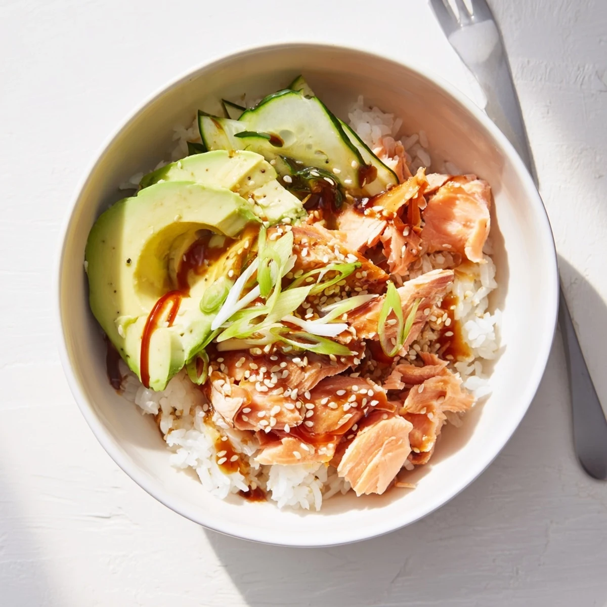 Delicious leftover salmon and rice bowl topped with fresh avocado and cucumber.  