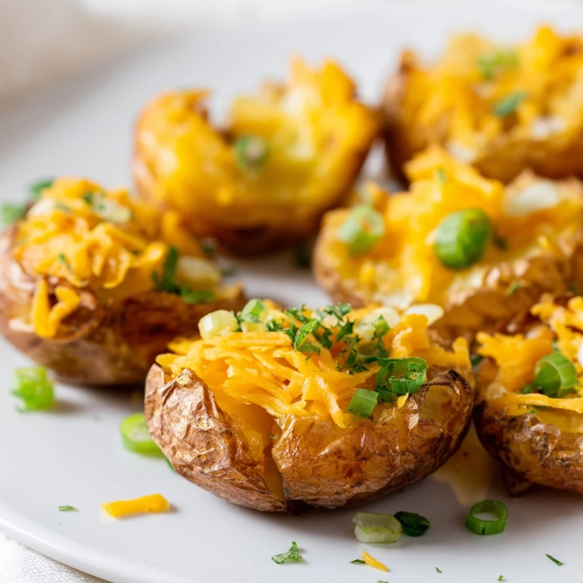 Crispy smashed green onion potato bombs topped with melted cheese, perfect for sharing.  