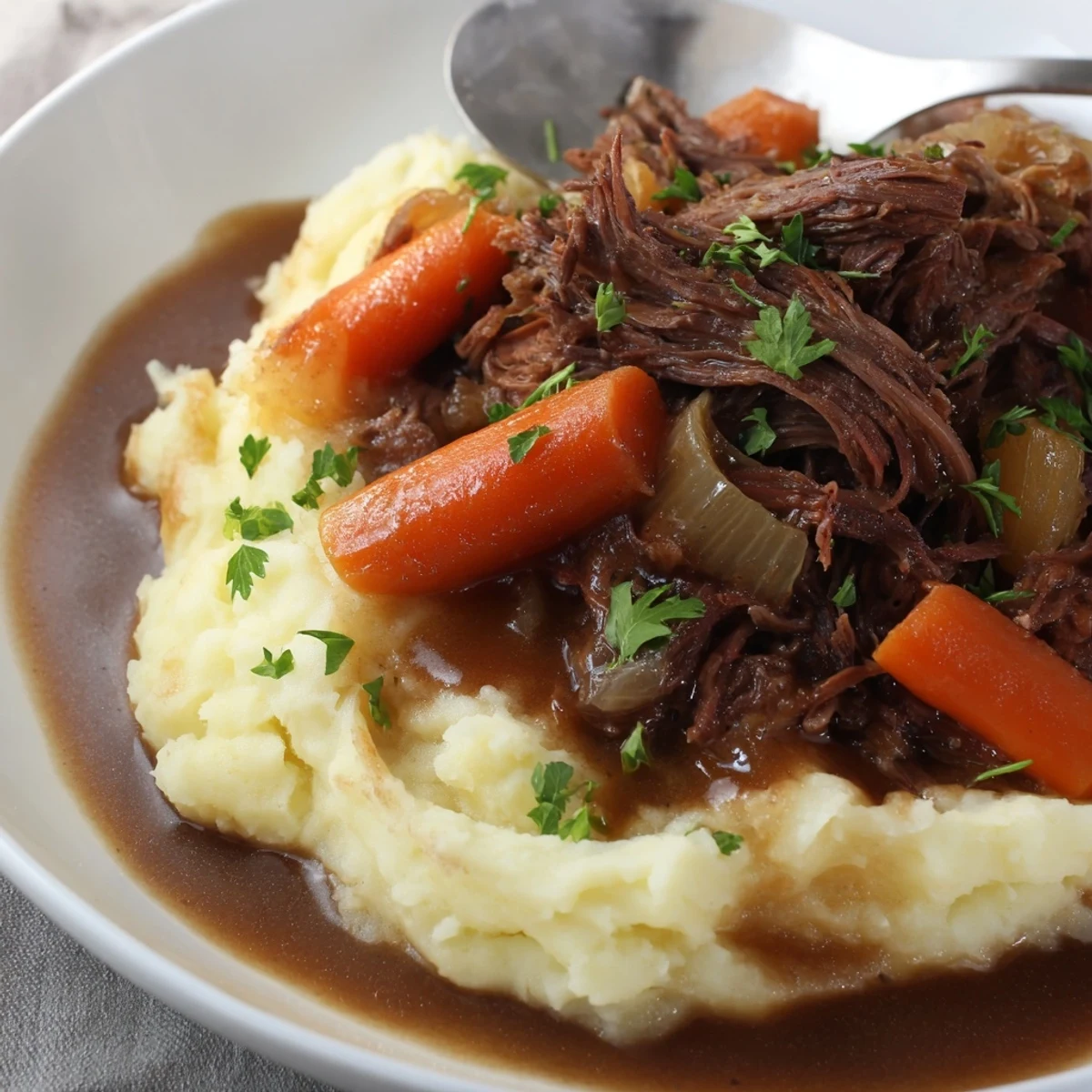 Aromatic slow cooker pot roast paired with buttery mashed potatoes and fresh parsley garnish.  