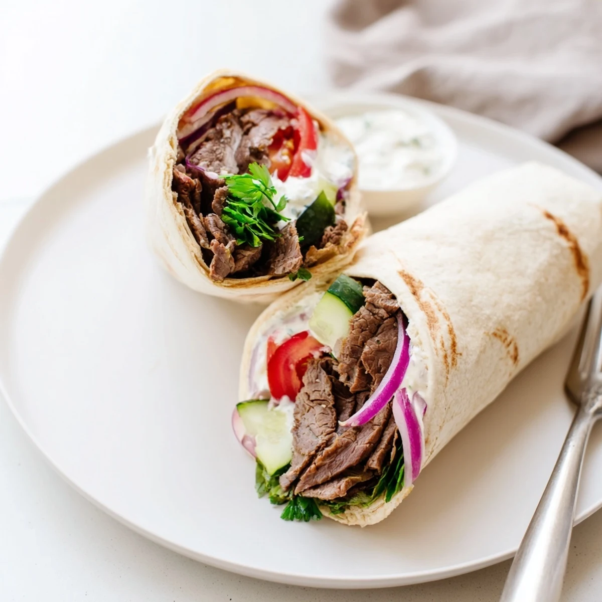Delicious beef shawarma wraps bursting with flavors, served with tangy yogurt sauce.  