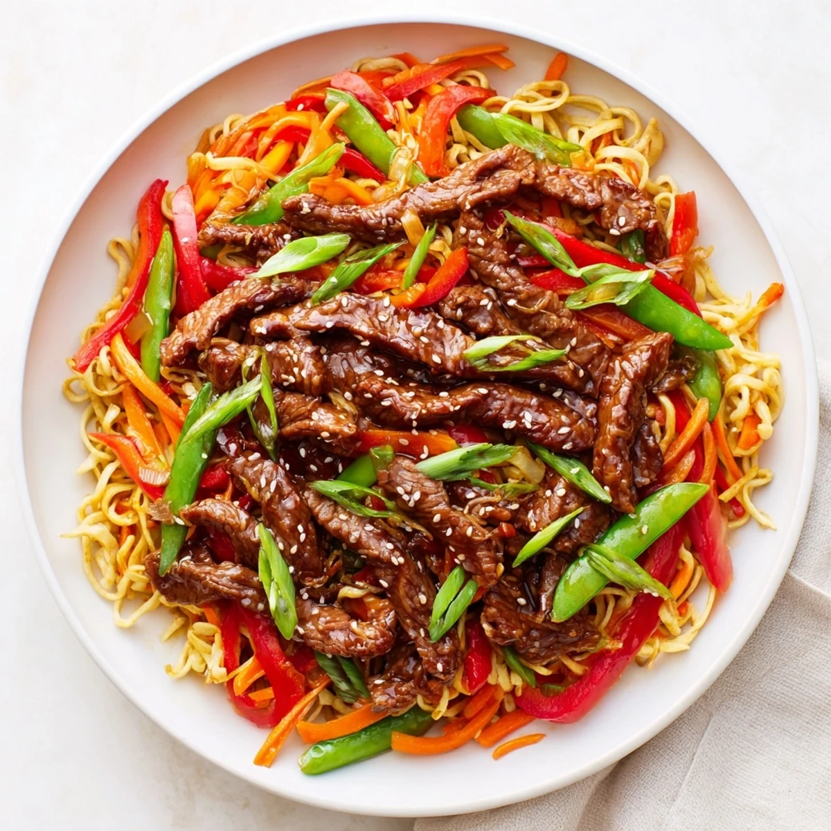 Vibrant Teriyaki Beef & Noodle Bowl with glistening sauce, sesame seeds, and fresh green onions.