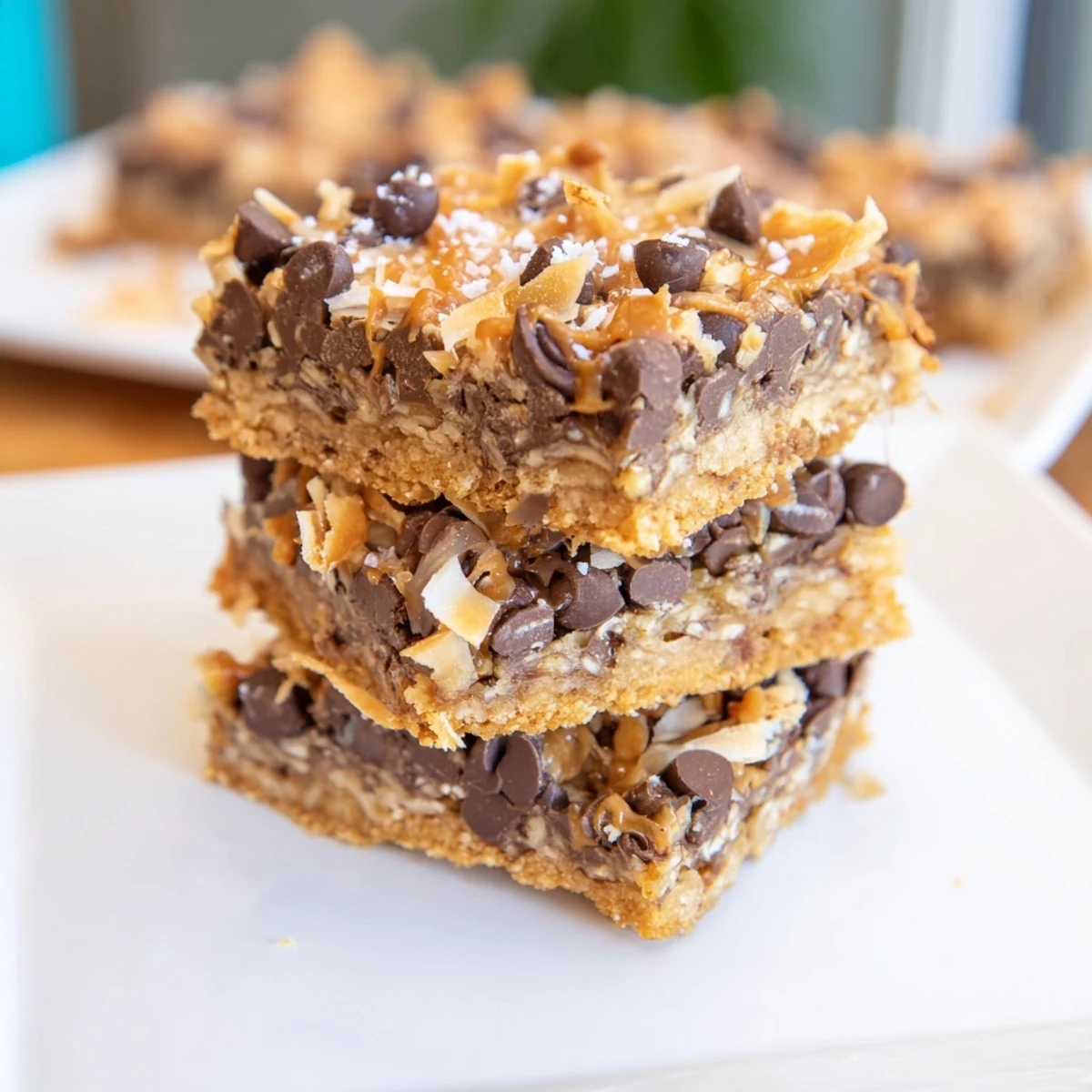 Golden, gooey squares of 7-Layer Magic Bars with sea salt caramel drizzle; a perfect dessert treat.