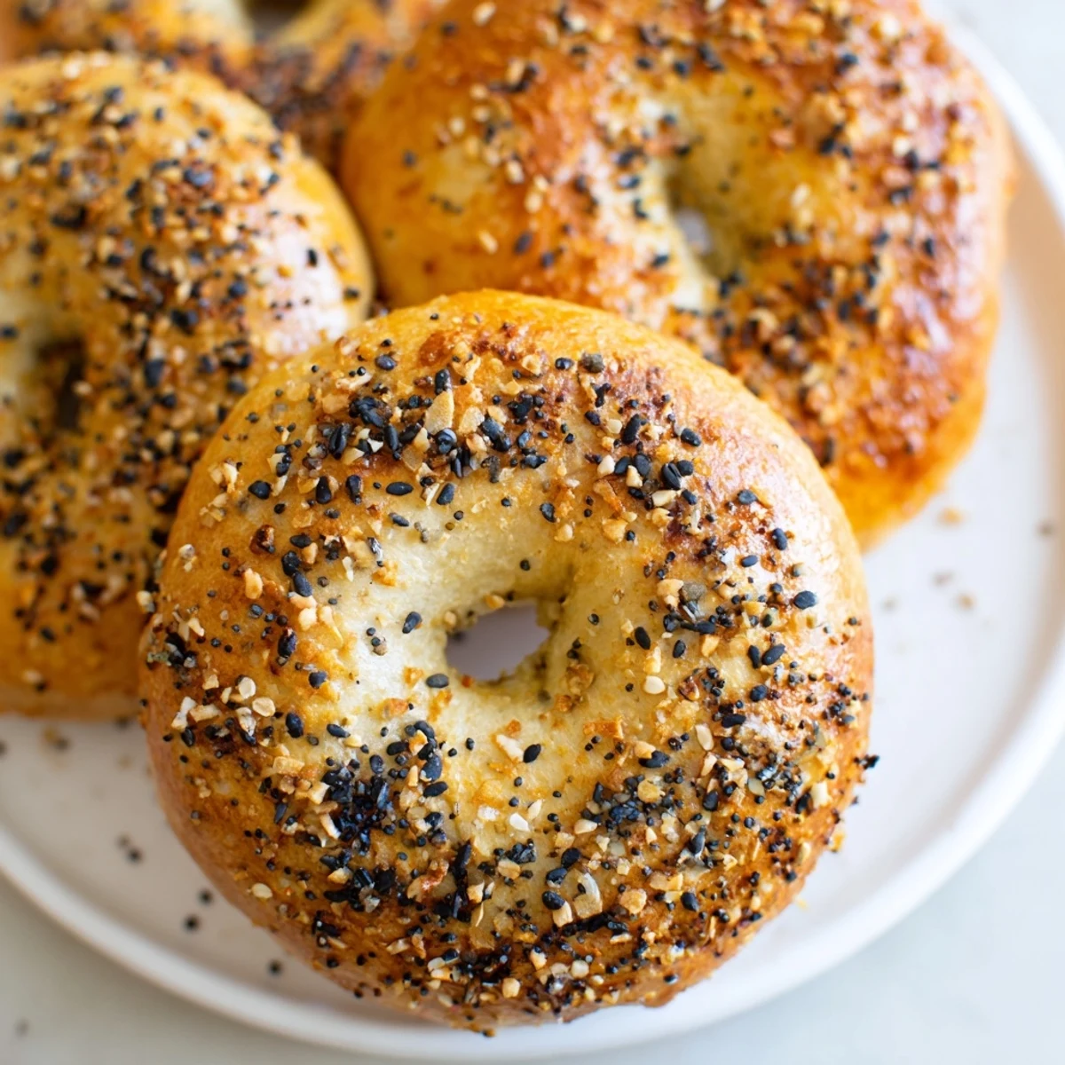 Close-up of fluffy homemade Everything Bagel Yogurt Bagels, enticingly topped and perfect for a quick breakfast.