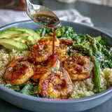 Flavorful Detox Buddha Bowl featuring tender shrimp, quinoa, and crisp vegetables drizzled.