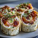 Creamy dill-infused cheese spread over tortillas, topped with smoked salmon and crisp cucumber, rolled into beautiful pinwheels.