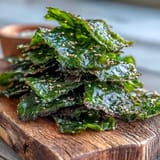 Golden seaweed snack chips sprinkled with sea salt and sesame, ready to eat.