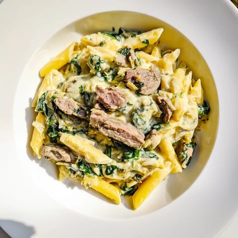 Golden bubbly Steak & Spinach Artichoke Pasta Bake fresh from the oven, enticing aroma filling the kitchen.