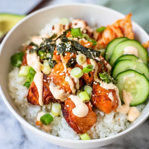 Deliciously layered crispy salmon rice bowl topped with kimchi, avocado, and scallions.  