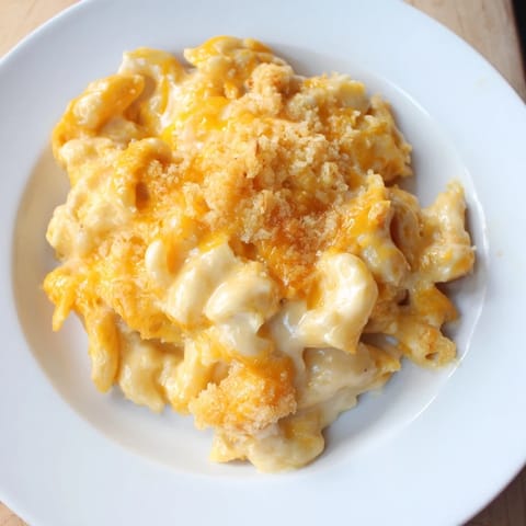 Warm, creamy Mac & Cheese with Evaporated Milk, pictured bubbling in an oven-safe dish.
