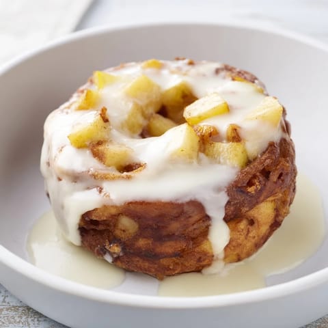 Freshly made apple fritters, bursting with cinnamon scents and tender apple chunks, ready to enjoy.