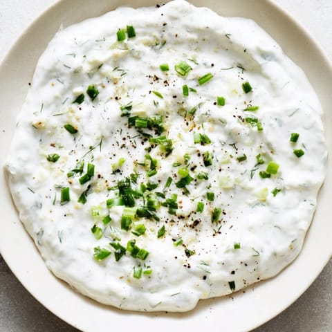 Homemade Greek Yogurt Ranch Dip, a healthy and light appetizer, brimming with fresh herbs for serving.