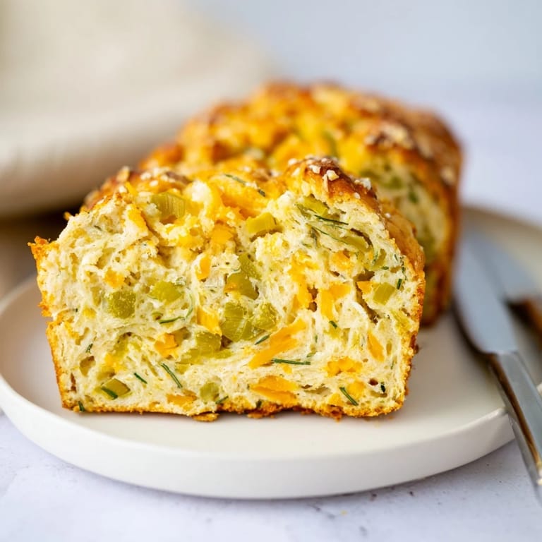 Freshly baked Dill Pickle Cheddar Pretzel Muffin Loaf garnished with coarse sea salt.