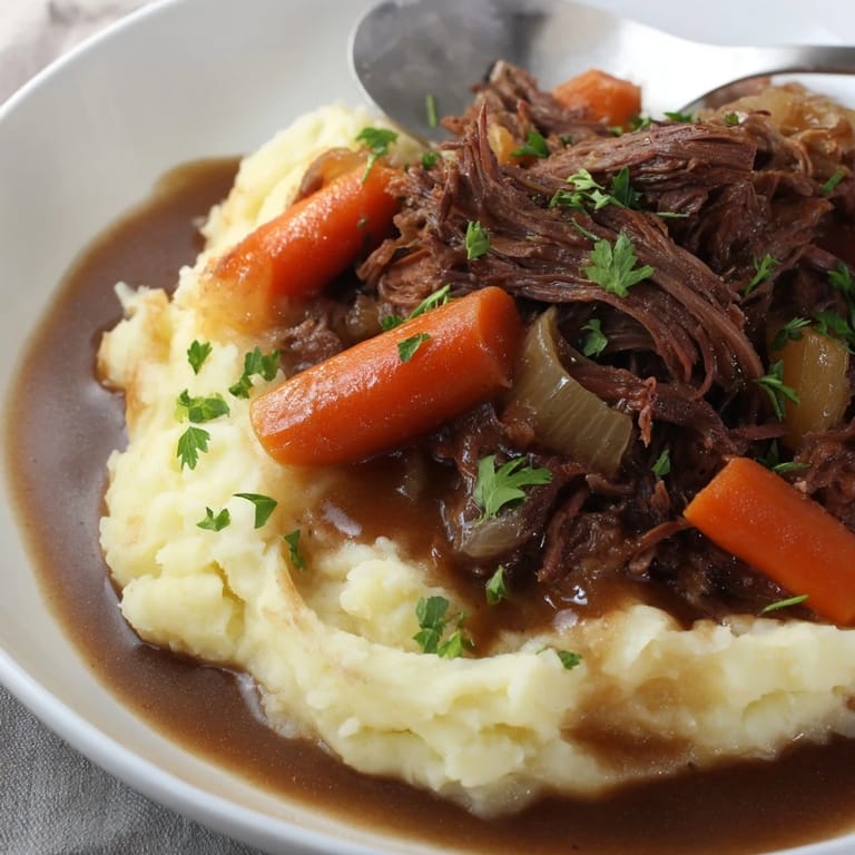 Aromatic slow cooker pot roast paired with buttery mashed potatoes and fresh parsley garnish.  