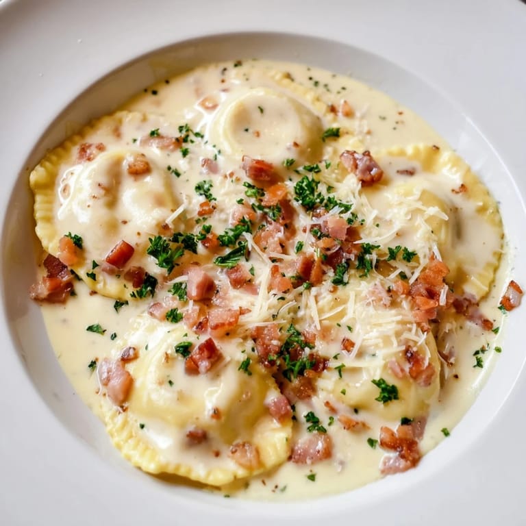 A steaming bowl of Olive Garden Ravioli Carbonara, topped with savory pancetta and fresh parsley for a delightful meal.