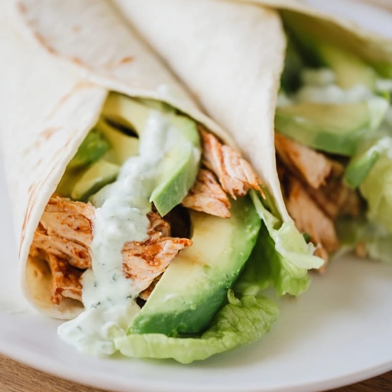 Freshly assembled Smoky Chipotle Chicken Wraps with vibrant red onion and diced tomato, ready to be served for a quick and spicy lunch.